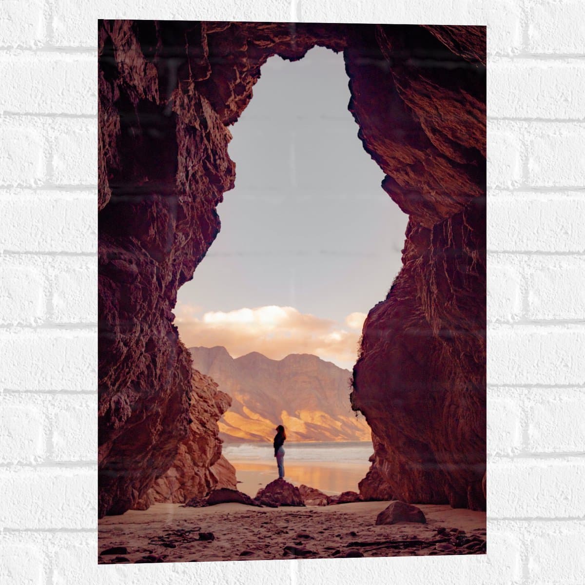 Muursticker - Vrouw in een Grot bij het Strand - 40x60 cm Foto op Muursticker